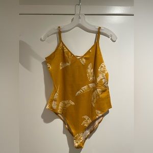 Mustard colored leotard with floral designs